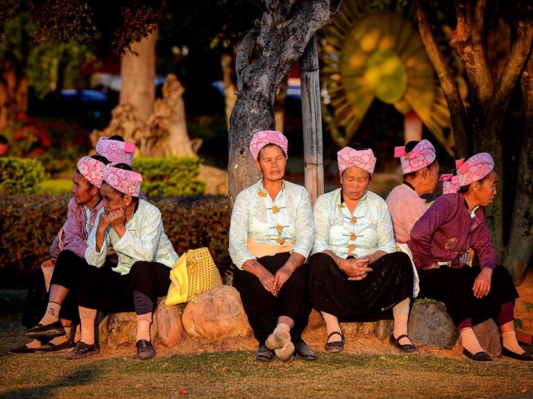 Dai women invited by their fellow Jingpo neighbors to celebrate the Munao festival in Mangshi, Yunnan,…