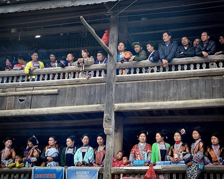 Miao families watching the yearly celebration of the Lusheng Festival from their balcony