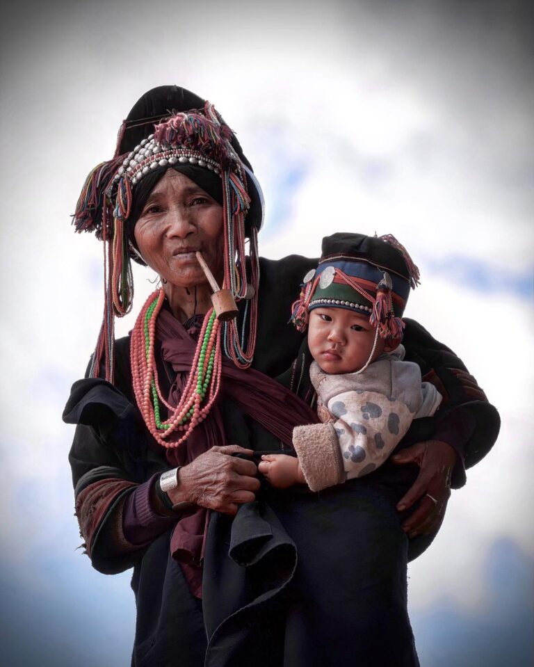 Strong bond between a grandmother and grandson from the Akha “sharp-headed” tribe, from Menglian, in Yunnan,…