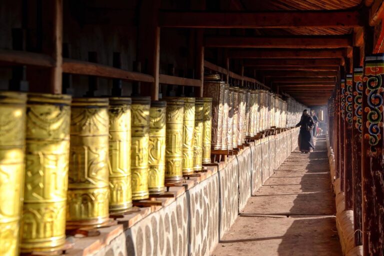 Tibetan woman spinning prayer wheels around the Langmu Monastery (སྟག་ཚང་ལྷ་མོ་ 郎木寺), Gansu, China