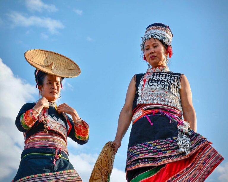 Women from the "Flower-waist" branch of the Dai ethnic group, posing from their rooftop