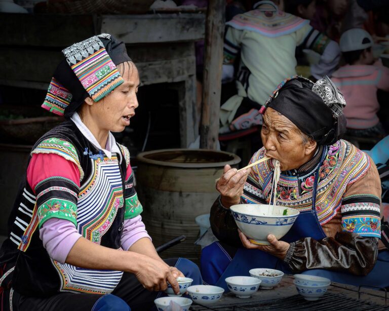 Yi women enjoying their “mixian” at Panzhihua market, Honghe, Yunnan