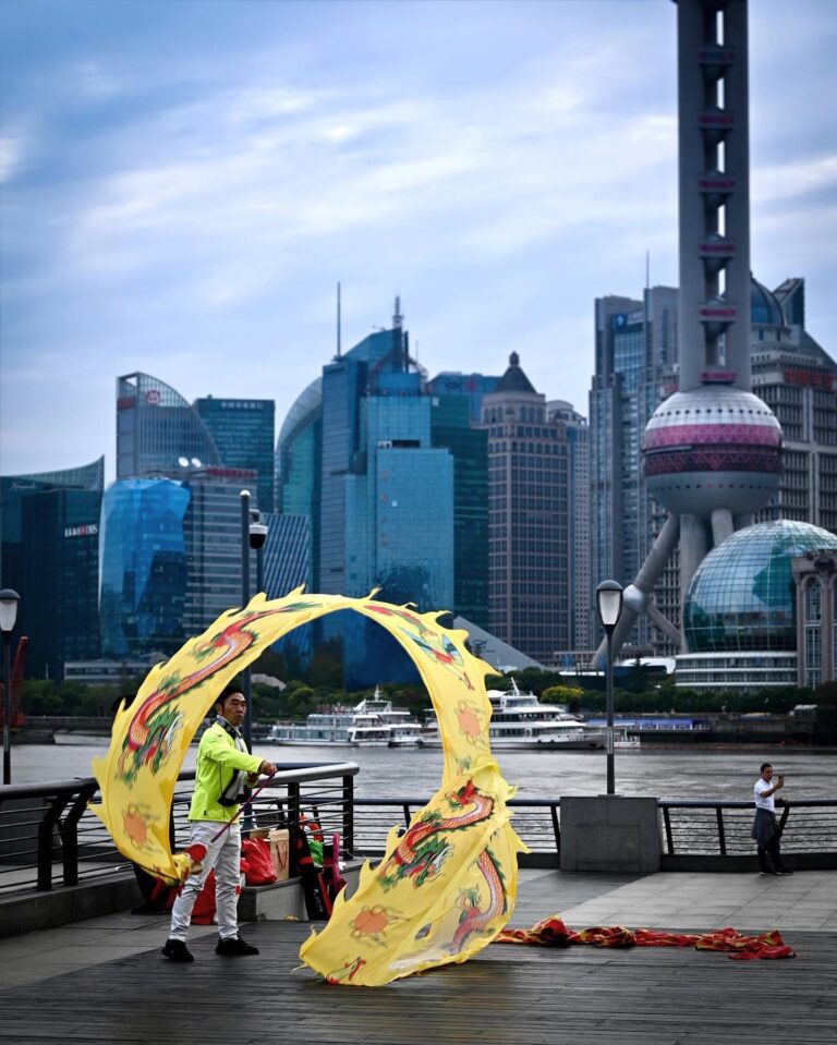 Dragon banner dance on the Bund, in Shanghai, with a view of the Pudong Business District skyline