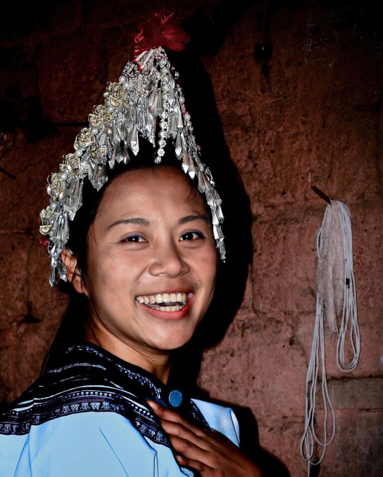 Young Yi woman from Honghe, Yunnan, wearing the traditional "Rooster Hat", typical of her ethnic group (more…