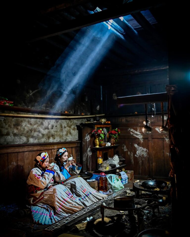 Yingzhaji and her sister Jima enjoying tea in their traditional Naxi living room, featuring classic…