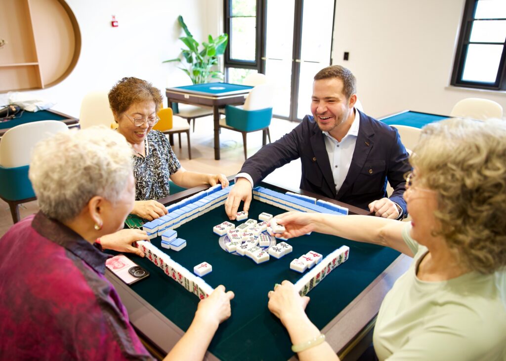 Nathaniel Farouz playing mahjong with residents at Sindora Living in Nanjing.